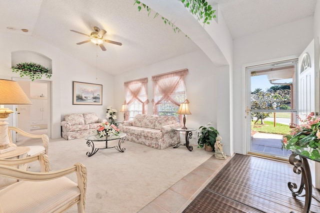 carpeted living room with a textured ceiling, ceiling fan, and lofted ceiling