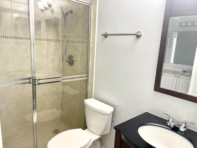 bathroom featuring vanity, an enclosed shower, and toilet