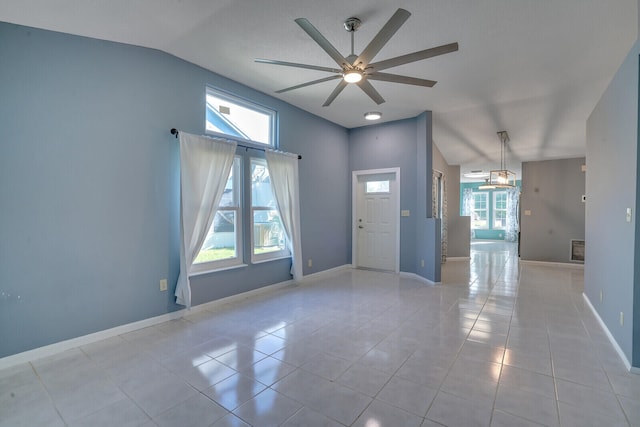 tiled empty room with ceiling fan, a healthy amount of sunlight, and vaulted ceiling