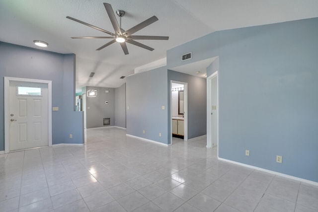 unfurnished living room with ceiling fan, light tile patterned floors, and vaulted ceiling