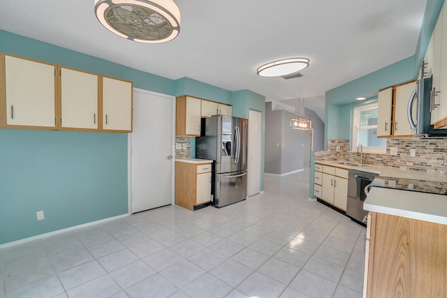 kitchen with pendant lighting, sink, appliances with stainless steel finishes, tasteful backsplash, and light tile patterned flooring