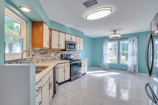 kitchen with decorative backsplash, appliances with stainless steel finishes, white cabinets, and sink