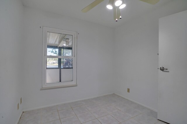 empty room with ceiling fan and light tile patterned flooring