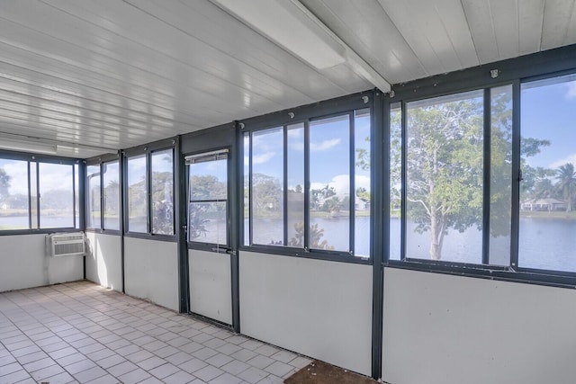 unfurnished sunroom with a wall unit AC and a water view