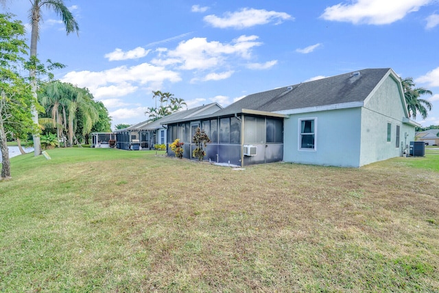 back of property with central AC, a sunroom, a yard, and cooling unit