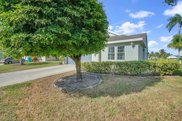 obstructed view of property with a garage and a front lawn