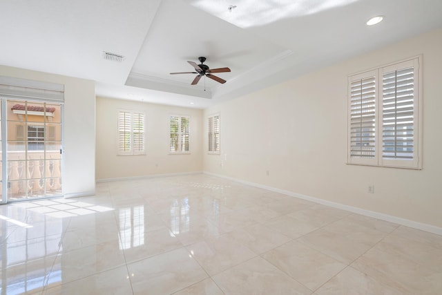 unfurnished room with visible vents, baseboards, a raised ceiling, and ceiling fan