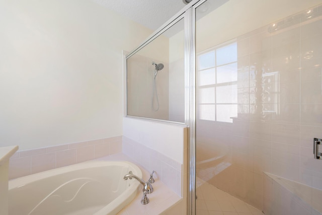 bathroom with independent shower and bath and a textured ceiling