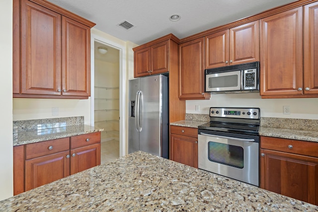 kitchen with light stone countertops and stainless steel appliances