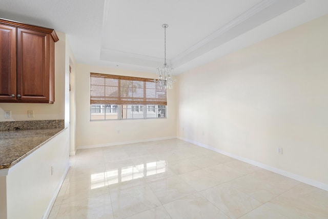 unfurnished dining area with light tile patterned floors, a tray ceiling, crown molding, and a chandelier