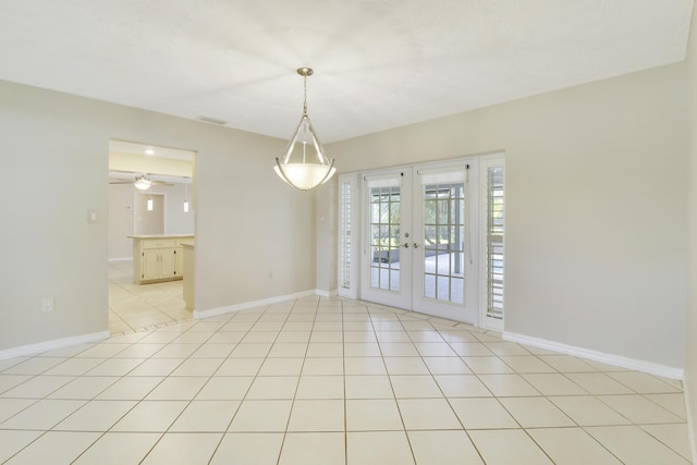 unfurnished dining area featuring ceiling fan, french doors, and light tile patterned flooring