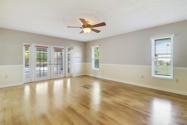 unfurnished room featuring a healthy amount of sunlight, light wood-type flooring, and french doors