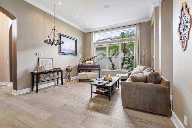 living room with light hardwood / wood-style flooring, crown molding, and a notable chandelier