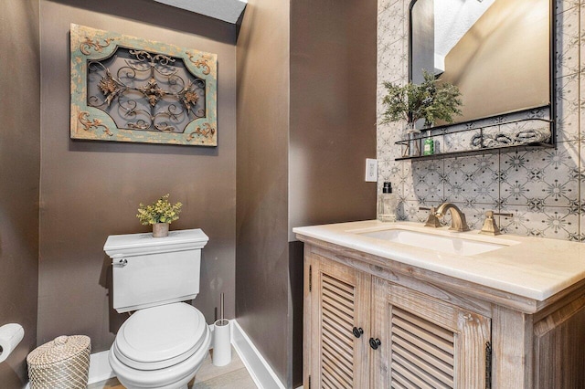 bathroom with vanity, backsplash, and toilet