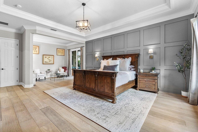 bedroom featuring a chandelier, light hardwood / wood-style floors, and ornamental molding