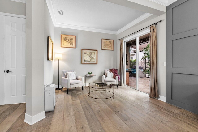 sitting room with light hardwood / wood-style flooring and ornamental molding