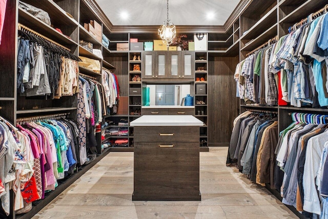 walk in closet featuring a chandelier and light hardwood / wood-style floors