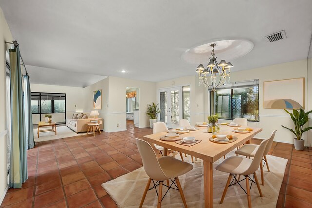 dining space featuring plenty of natural light, tile patterned floors, and an inviting chandelier