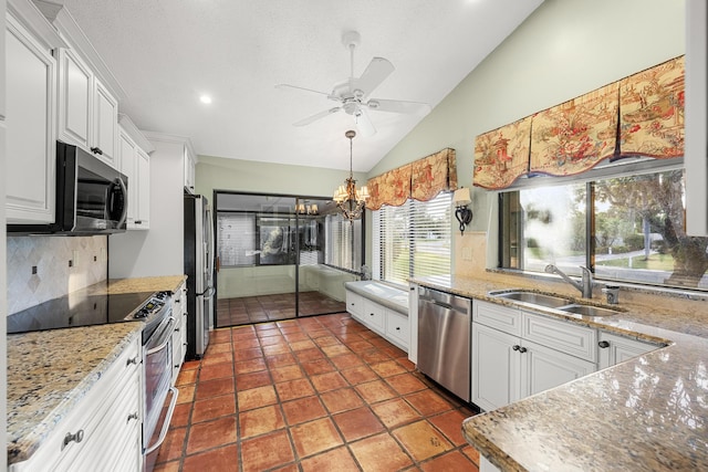 kitchen featuring white cabinets, stainless steel appliances, tasteful backsplash, sink, and vaulted ceiling