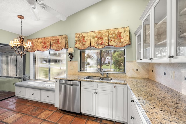 kitchen with stainless steel dishwasher, white cabinets, vaulted ceiling, and sink