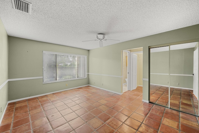 unfurnished room featuring a textured ceiling, ceiling fan, and light tile patterned flooring