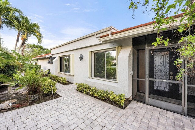 view of exterior entry featuring a patio