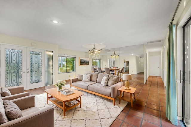 living room with french doors, a chandelier, and tile patterned flooring