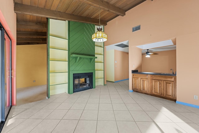 unfurnished living room with wooden ceiling, a multi sided fireplace, sink, ceiling fan, and light tile patterned floors