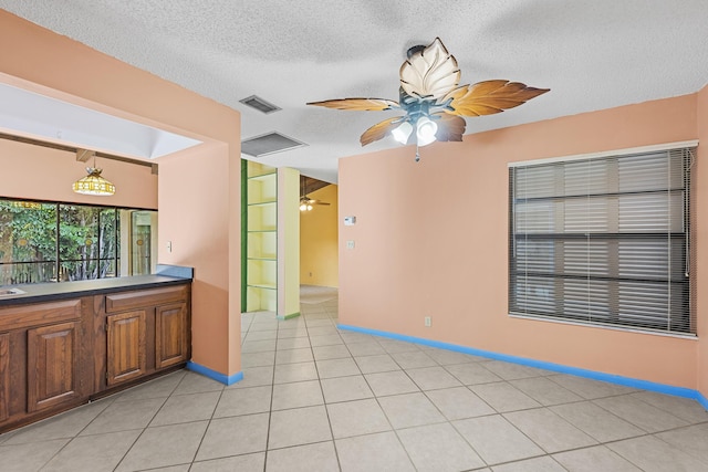 interior space featuring light tile patterned floors and a textured ceiling