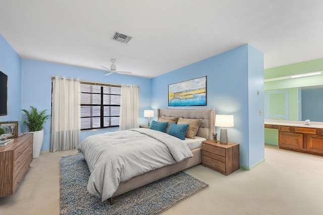 bedroom featuring ceiling fan, light colored carpet, sink, and connected bathroom