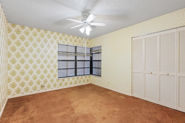 unfurnished bedroom featuring ceiling fan, carpet floors, a textured ceiling, and a closet