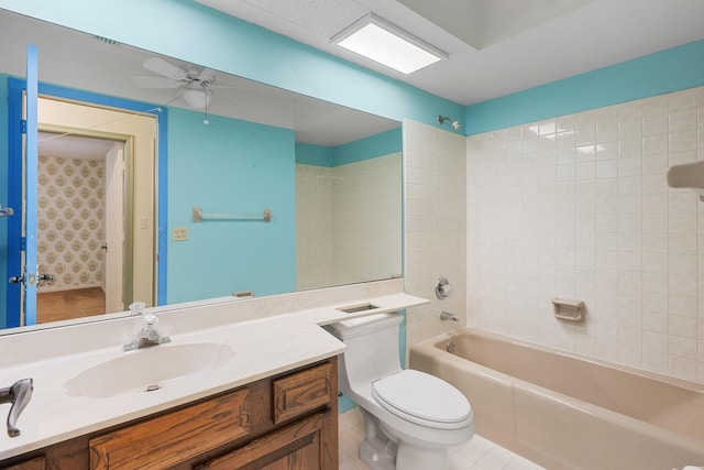 full bathroom with ceiling fan, tile patterned floors, toilet, vanity, and tiled shower / bath