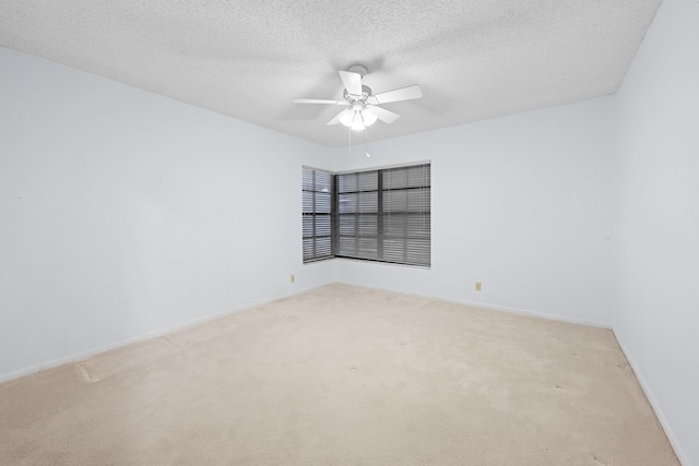 carpeted spare room with a textured ceiling and ceiling fan