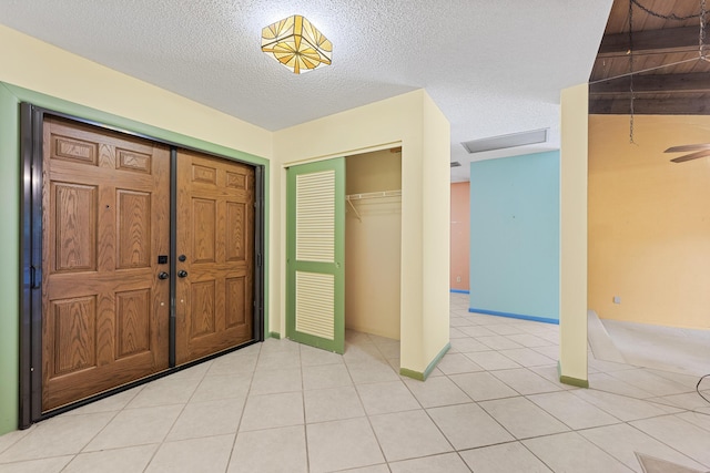 tiled entrance foyer with lofted ceiling and a textured ceiling