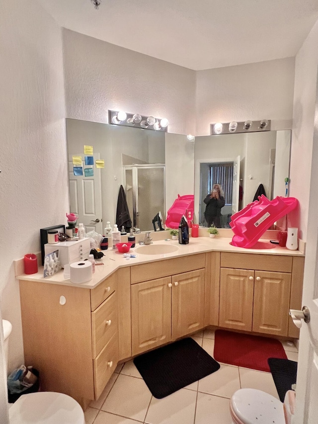 full bathroom with a stall shower, toilet, tile patterned floors, vanity, and a textured wall