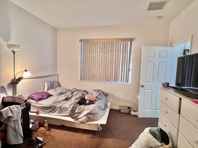 bedroom featuring visible vents and dark colored carpet