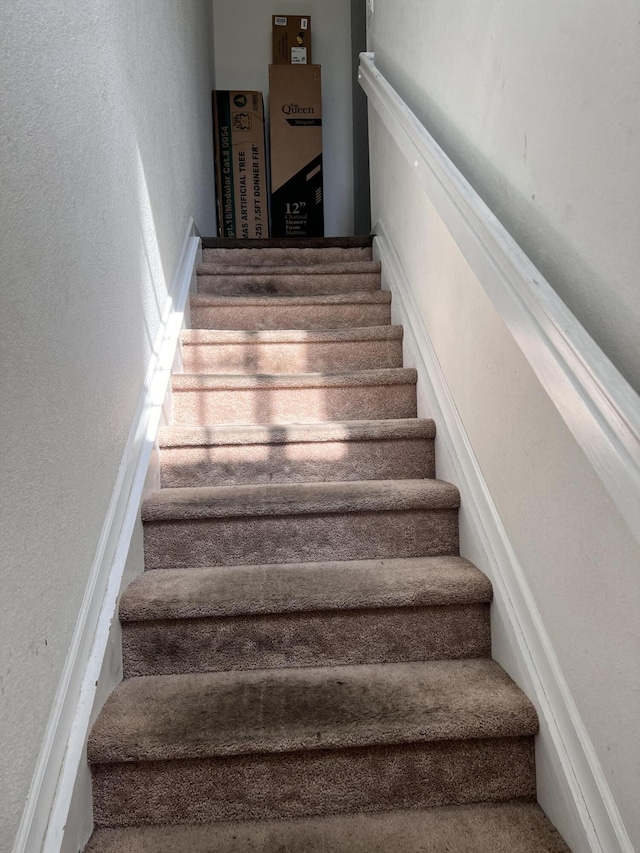 staircase featuring a textured wall