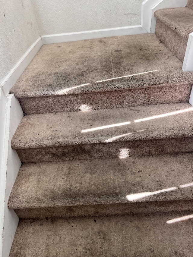stairs featuring a textured wall