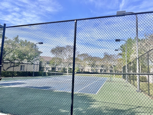 view of tennis court featuring fence
