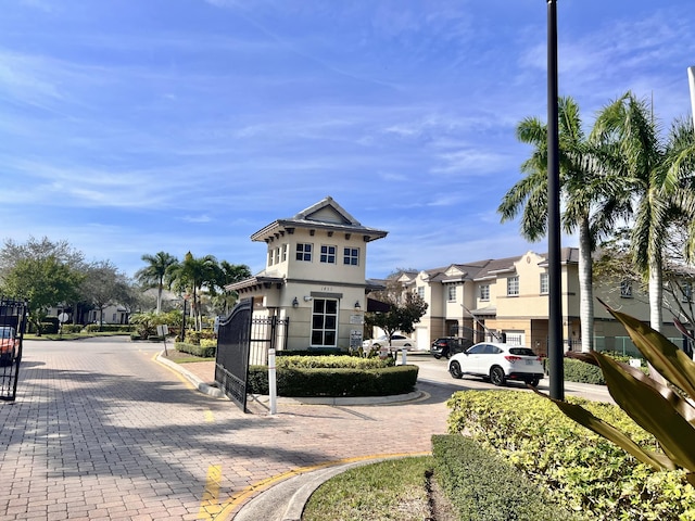 view of street featuring a gated entry, a residential view, and curbs