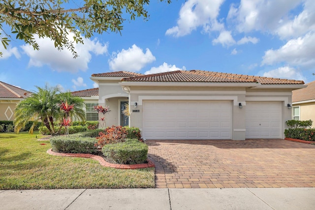 mediterranean / spanish-style home with a front yard and a garage