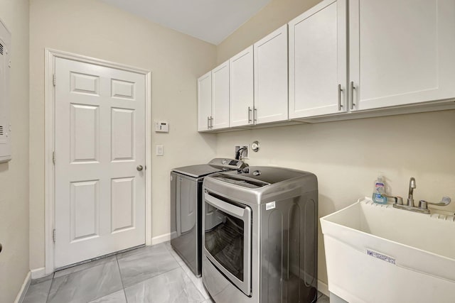 clothes washing area featuring sink, cabinets, and independent washer and dryer