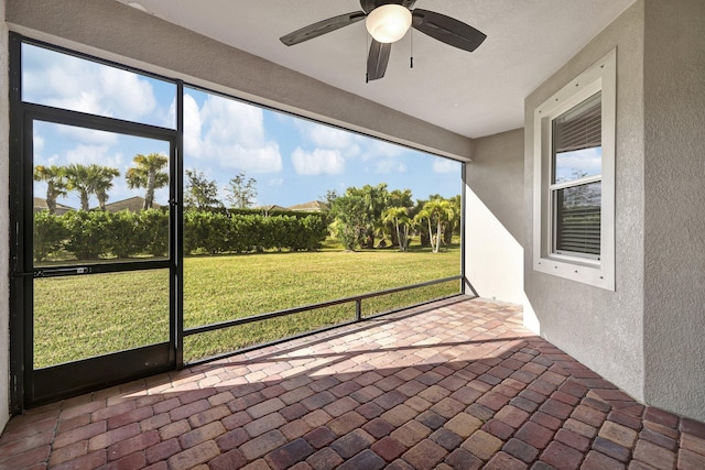 unfurnished sunroom featuring ceiling fan