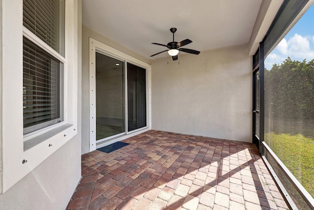 unfurnished sunroom featuring ceiling fan