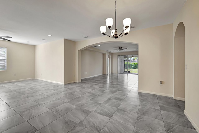 spare room featuring ceiling fan with notable chandelier