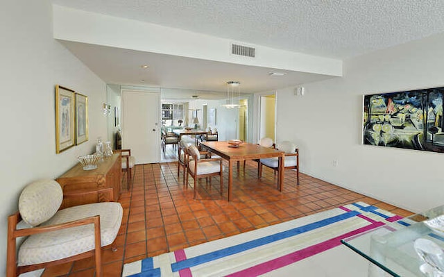 tiled dining space with a textured ceiling