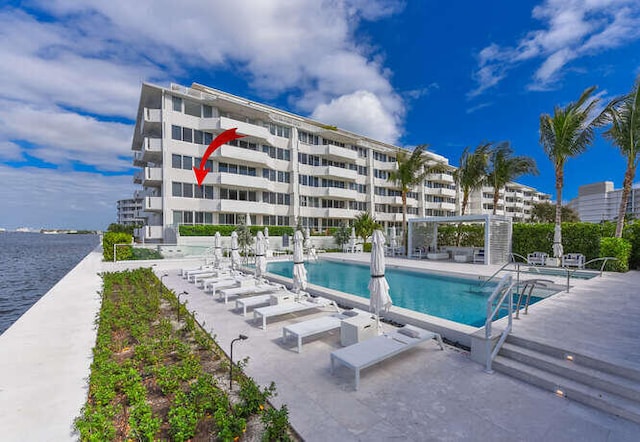 view of swimming pool featuring a patio area and a water view