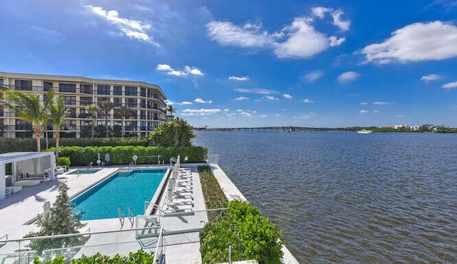 view of swimming pool with a patio area and a water view