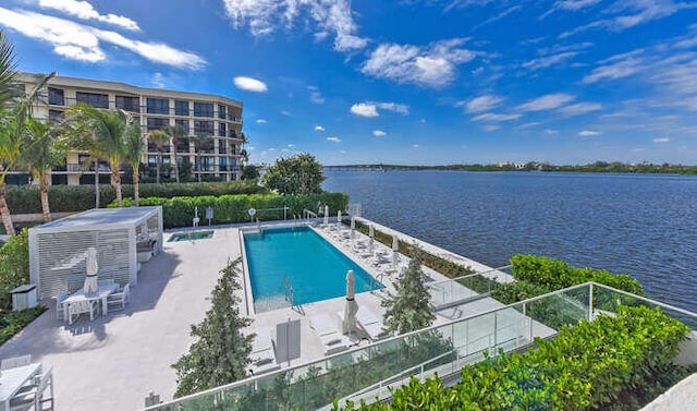 view of pool featuring a water view and a patio