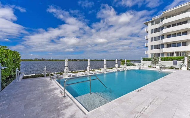 view of pool featuring a patio area and a water view